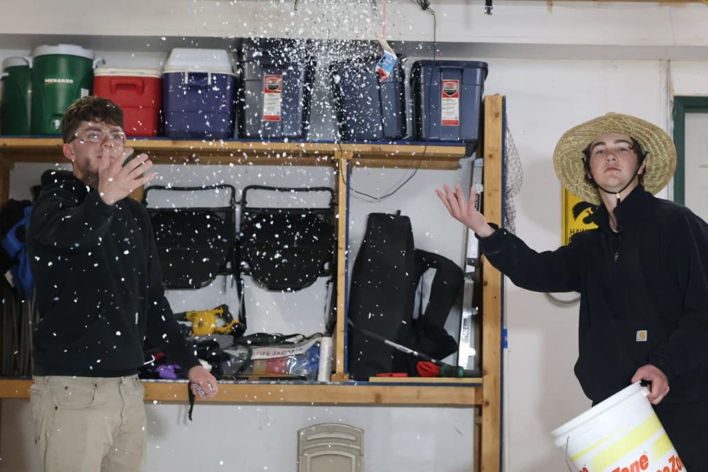 M-Pact Concrete Coatings crew broadcasting decorative flake during a garage floor install.