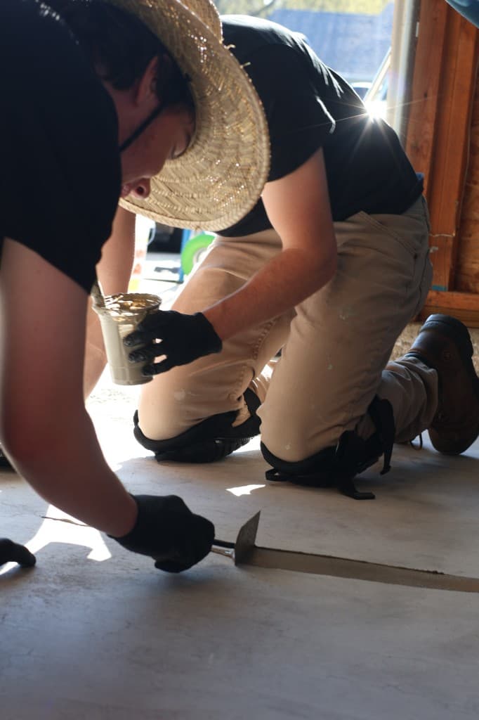 M-Pact crew patching and repairing cracks in a concrete floor before coating.