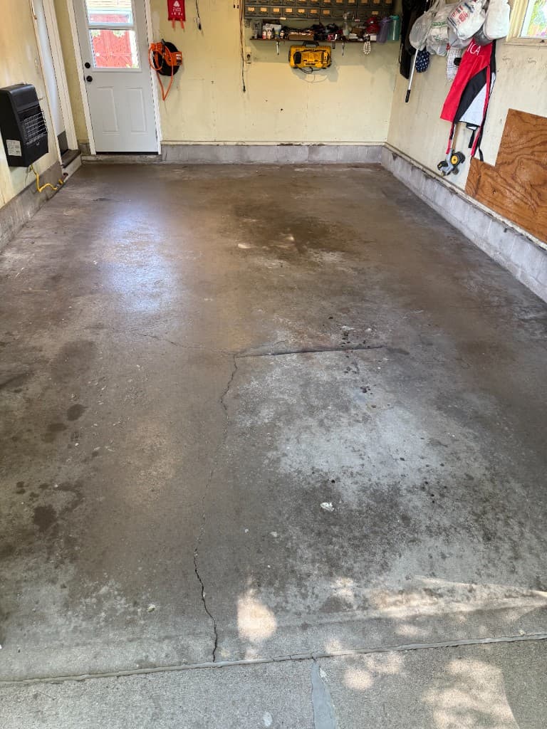 Worn, stained garage floor before M-Pact concrete coating.
