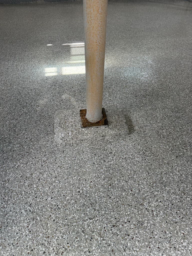 Creekbed flake floor coating detail around a support column.