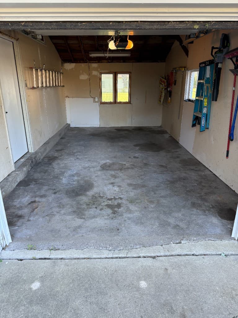 Stained single-car garage floor before coating.
