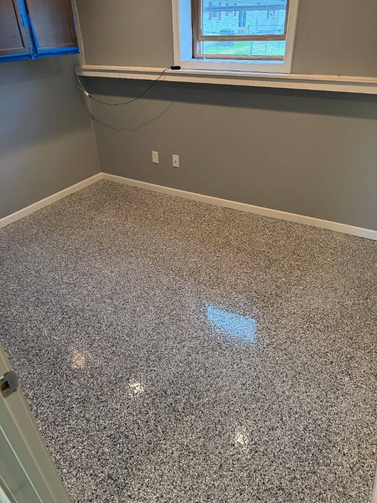 Finished room floor in Gravel flake coating with blue-gray walls.